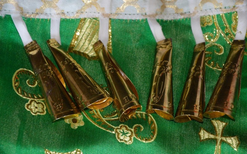 Bells worn during jingle dancing, set against a green and gold background