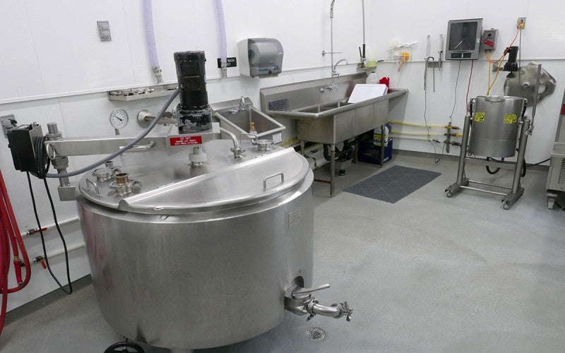 A large, metal cheese making device.