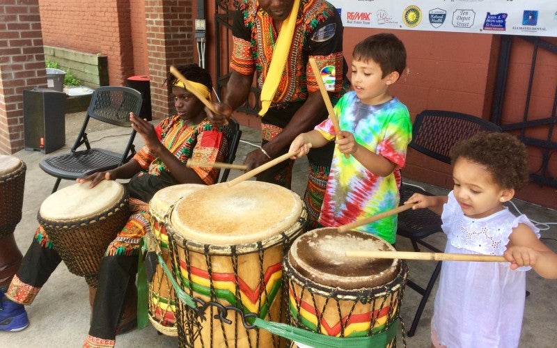 Alseny Yansane drums with two younger children
