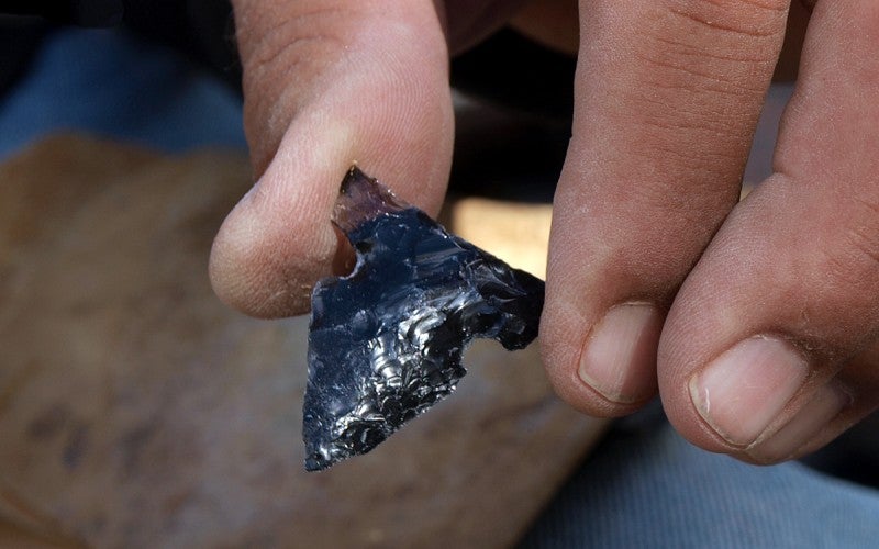 An arrowhead made from black obsidian.