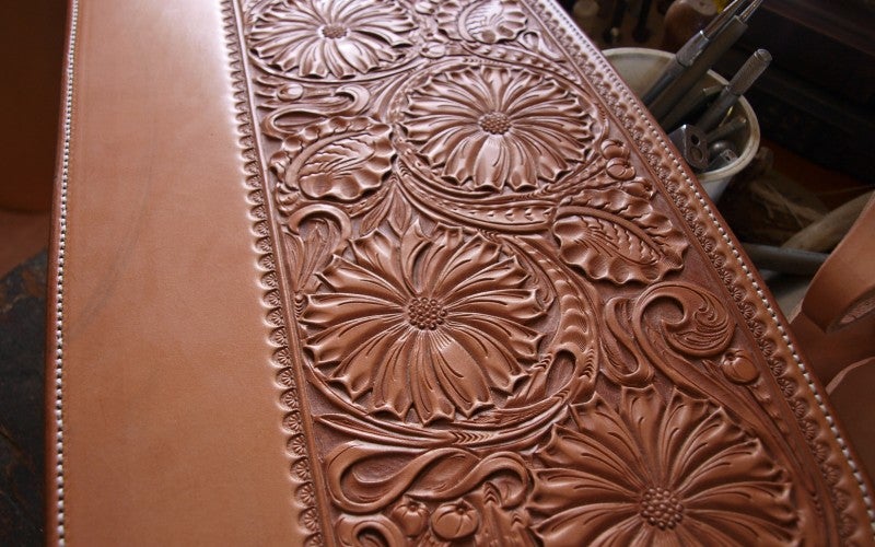 A strip of leather with an intricate floral design