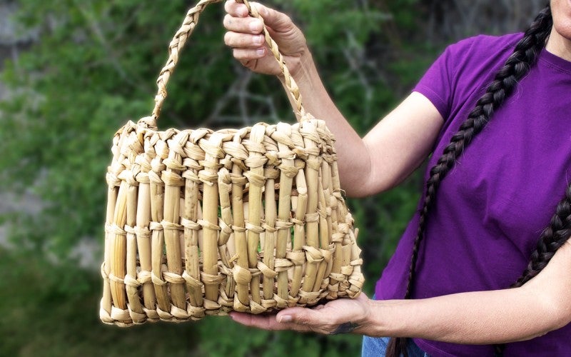 Sara holds up a woven basket with a handle