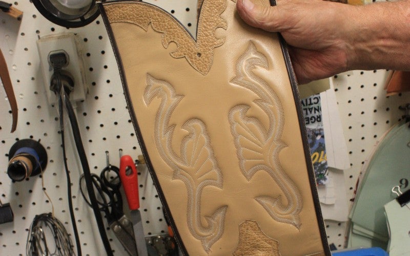 A tan piece of boot leather with detailed engravings.