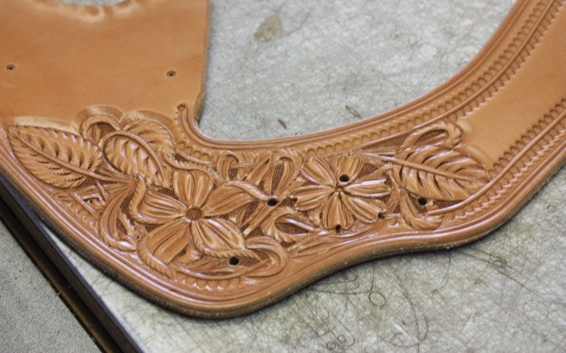 A piece of leather engraved with intricate flower designs.