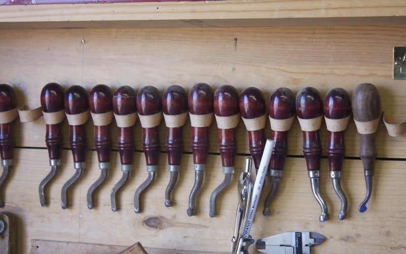 Six red saddle making tools.