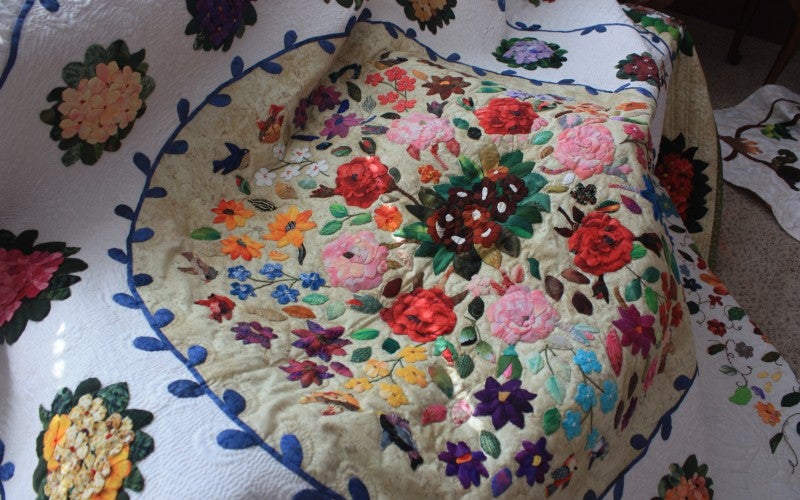 White quilt with circular flower designs.