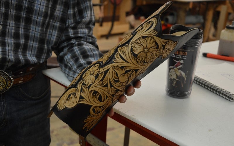 An intricately carved leather piece for a boot.