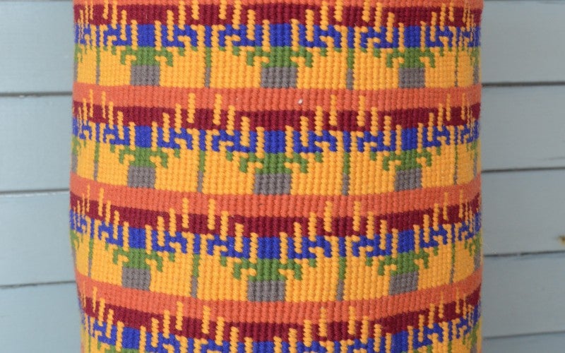 A yellow, red, orange, blue, and green woven basket.