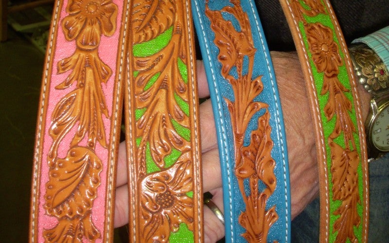 Four leather bands with floral detailing, background dyed pink, blue, and green.