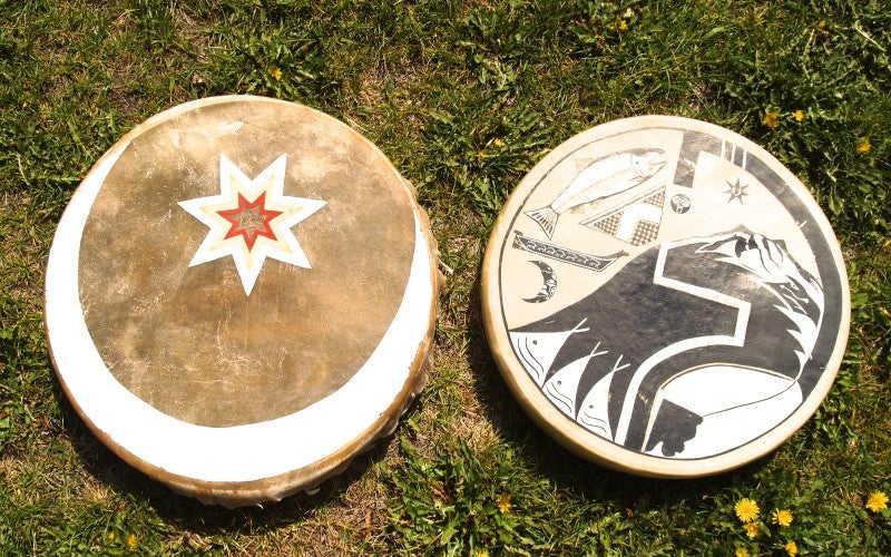 A circular tan item with mountain, fish, and canoe imagery.