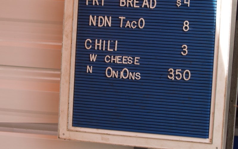 A menu sign reading "Kalamas" with pricing for fry bread, tacos, and chili.