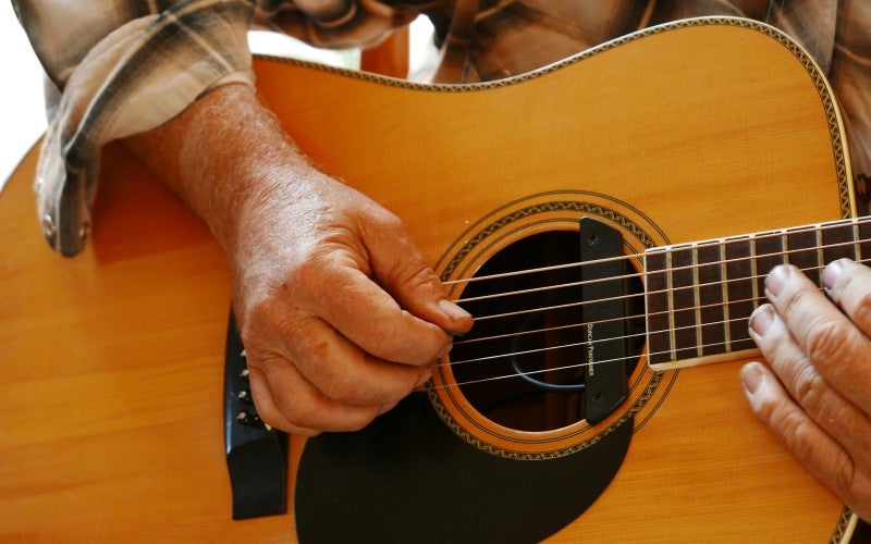 Close-up of artists hands while playing the guitar.