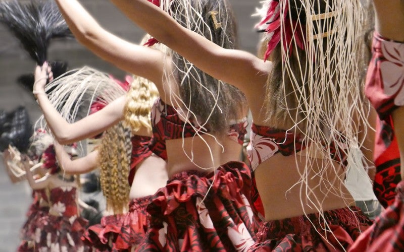 Group of people dancing with red hula outfits