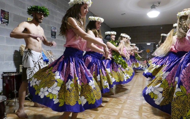 Group of people dancing with multicolored hula outfits
