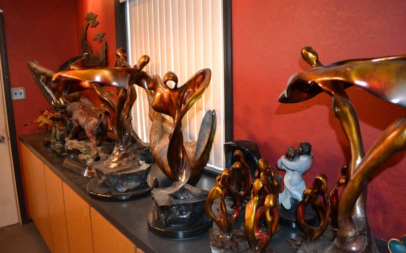 Many copper sculptures sit on a black counter