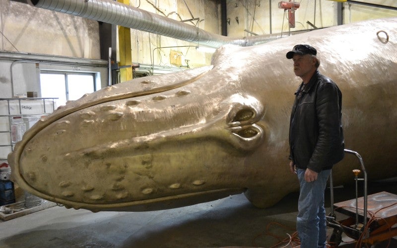 Parks stands next to a massive copper whale