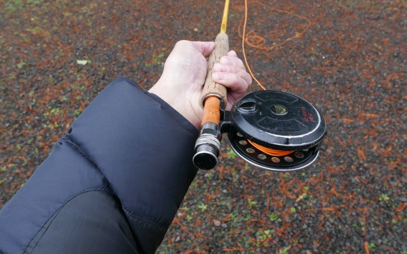 Close-up of man holding a fly-fishing rod.