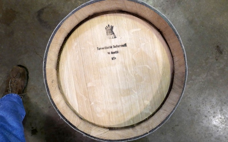 The end of a barrel, with a stamp that says "Tonnellerie DeFerrari 16 Month MT+"