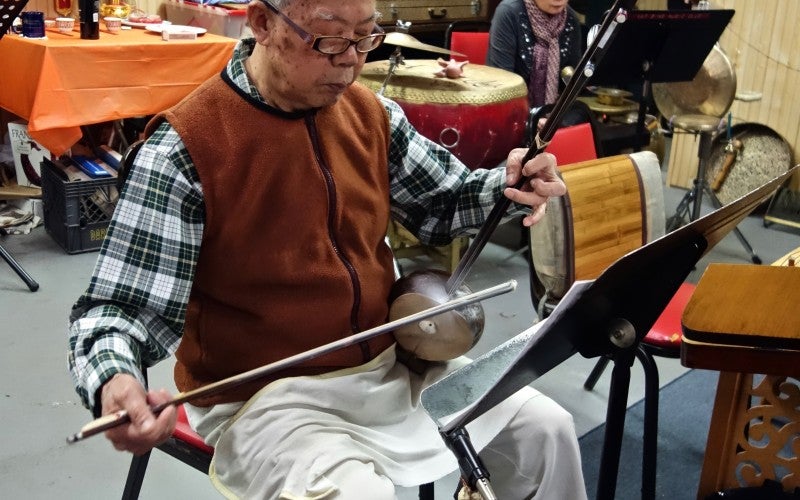 A member of the Yat Sing Music Club playing a stringed instrument