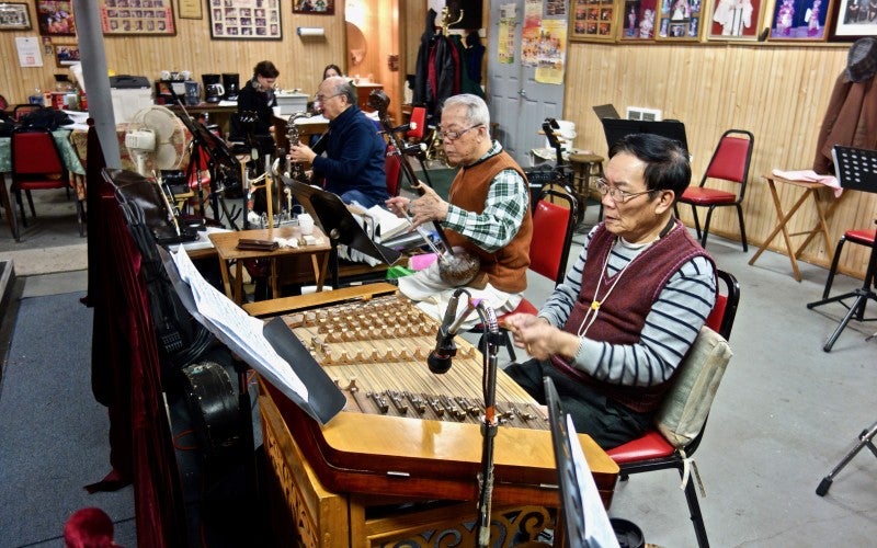 Yat Sing Music Club practice together, holding a variety of instruments