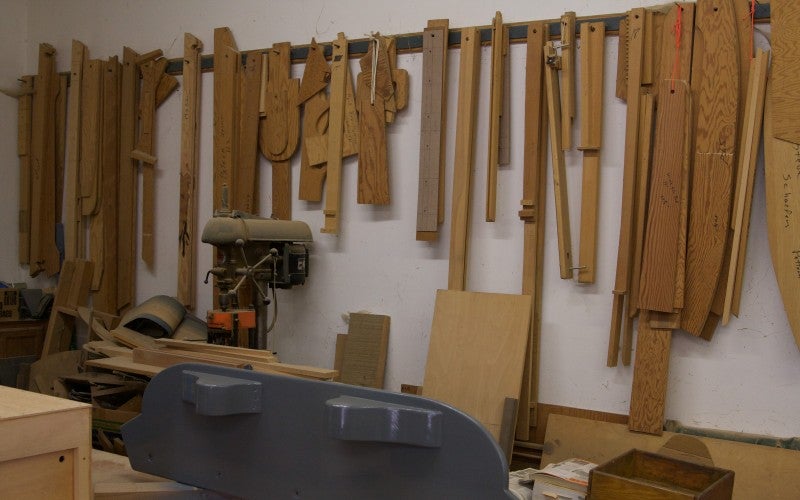 Wooden pieces hang above a workbench