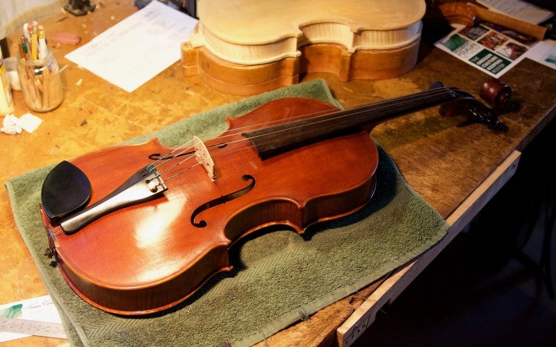 A violin sitting on a wooden table.
