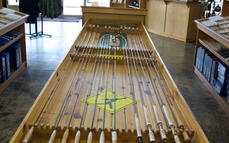A wooden rack of fly rods