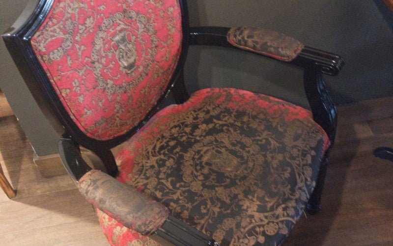 A wooden chair with red patterned upholstery. 