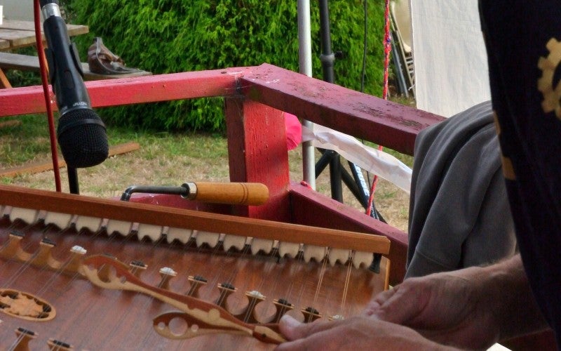 One member of the Brownsmead Flats performs a hammered dulcimer with small wooden mallets.