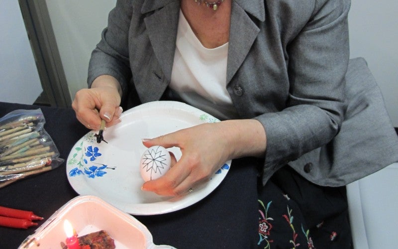 Mahoney holds a white egg with a snowflake design drawn onto it
