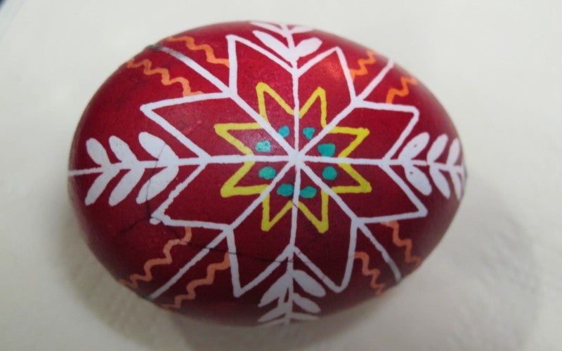 A red, white, orange, yellow, and blue decorated egg.