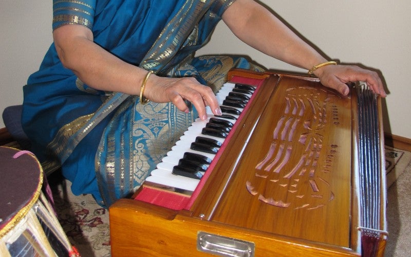 Nisha Joshi sits with an Indian classical instrument