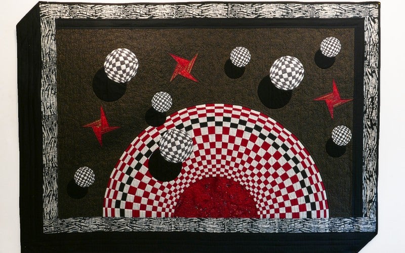 A red, white and black optical illusion quilt