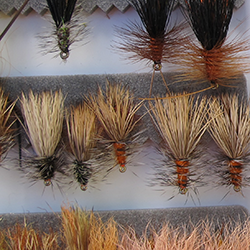 Three rows of brownish flies with bushy tails