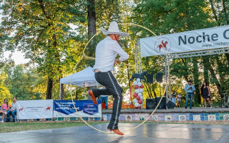 Antonio jumps through a rope circle at an outdoor event. 