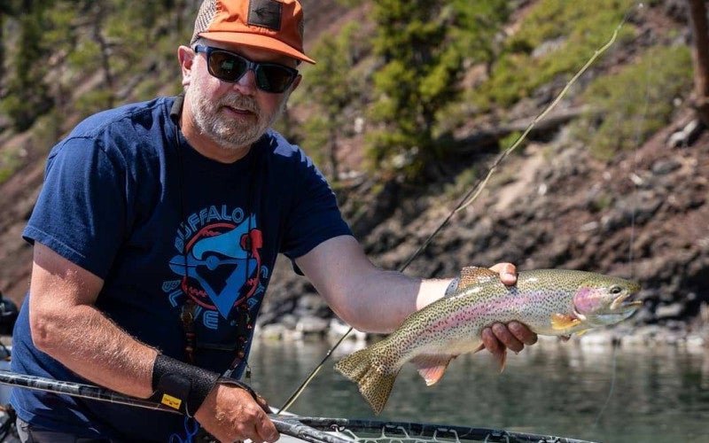 Jeff Perin holds a fish over a net