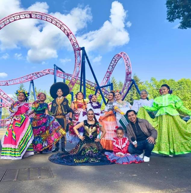 Kenya Marquez poses with a group of Mexican folk dancers at a theme park.