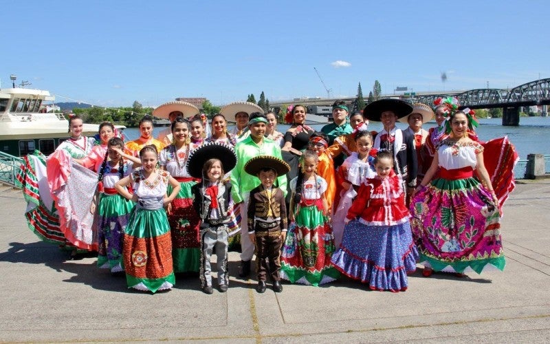 Kenya Marquez poses with a group of Mexican folk dancers at a marina.