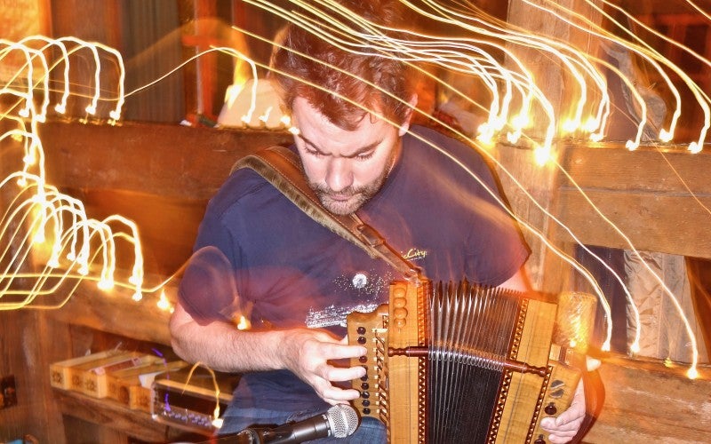 Johnny B. Connolly plays the accordion with lights swirling around.