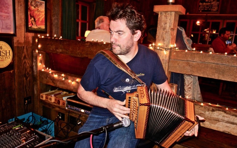 Johnny B. Connolly sits and plays the accordion