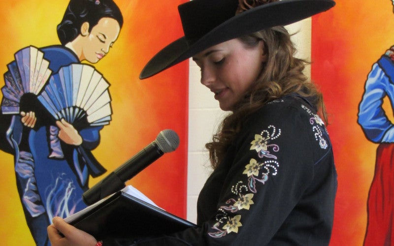 Randi Johnson performs a poem onstage. 