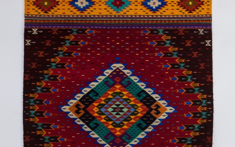 A patterned red, black and yellow rug.