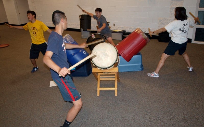 Janet and three of her students playing practice drums.