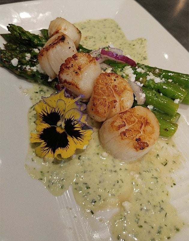 Local Ocean Scallop dish with asparagus and a pansy flower, Anderson is founder of this restaurant.