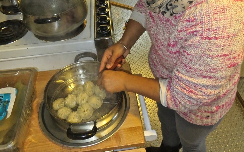 Ang Diki Sherpa cooking momo dumplings in a steam pan