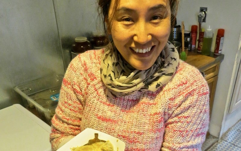 Ang Diki Sherpa showing the final product. Momo dumplings covered in a sauce.