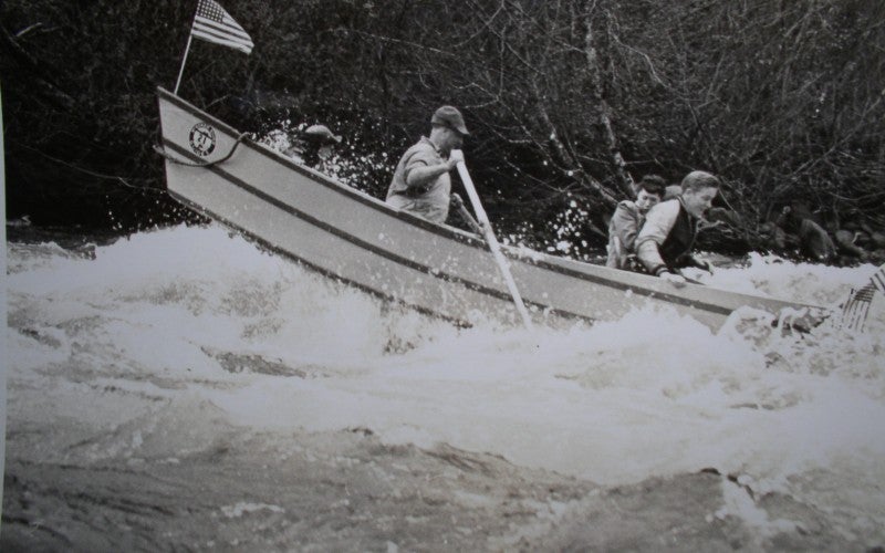 3 men on a boat in the midst of white water rapids