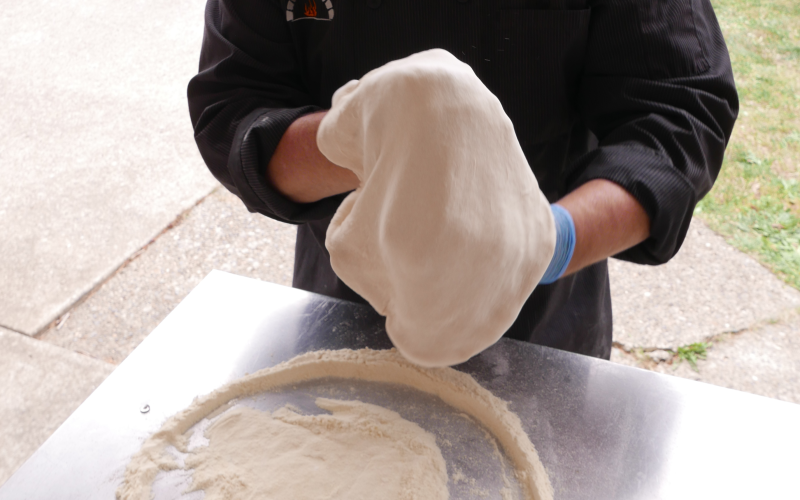 Frank Murphy making pizza dough, he is working the dough with his hands