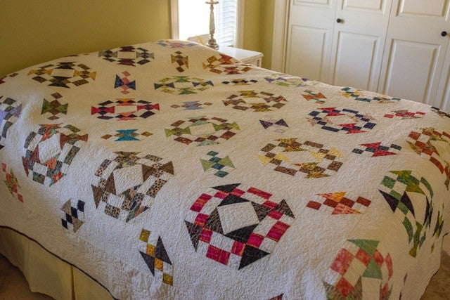A patterned quilt laying on a bed.