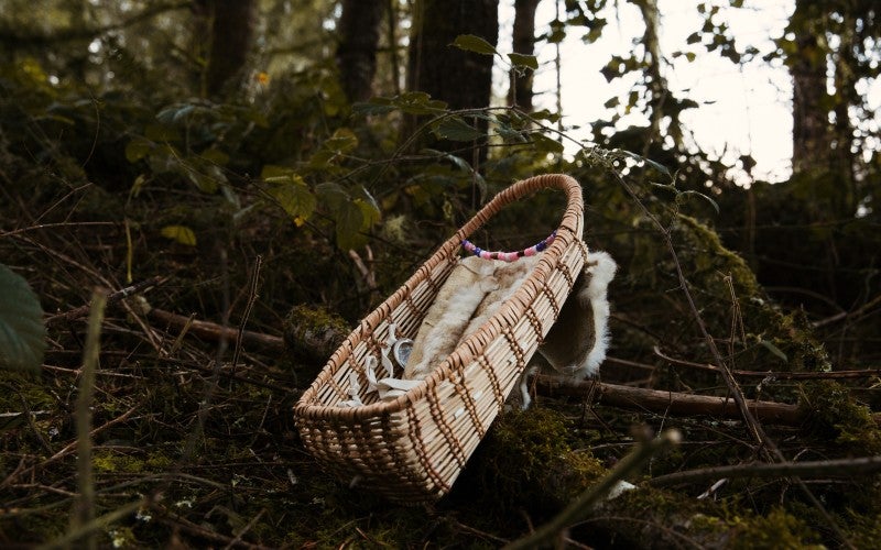Traditional Hazel and Spruce root newborn baby basket, rabbit fur, elk buckskin, sinew, beads and pine nuts, 2023.